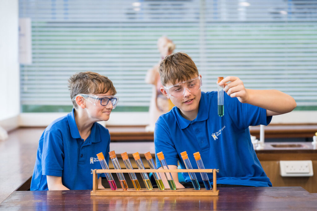 Students with a curious expression looking at vial during science class.